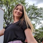 retrato de uma mulher sorridente de pe contra as arvores 1048944 10674773